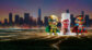 Two miniature superhero figures and a bottle of Altrini children's nutritional drink stand on a glowing surface with a city skyline in the background.